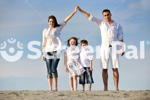 Family On Beach Showing Home Sign